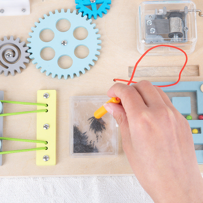 Close-up of busy board gears, music box and lacing