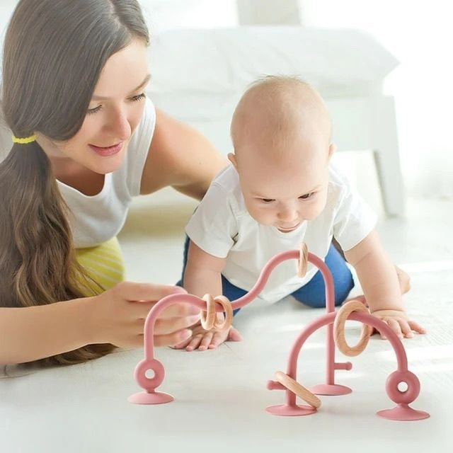 Baby playing with a silicone suction ring arch toy