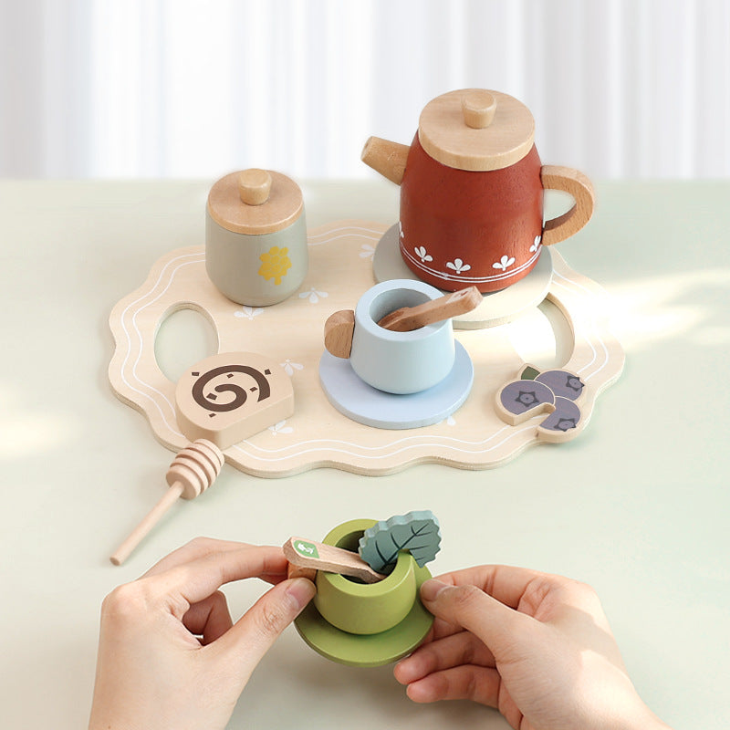 Child playing with a wooden tea party set on a tray