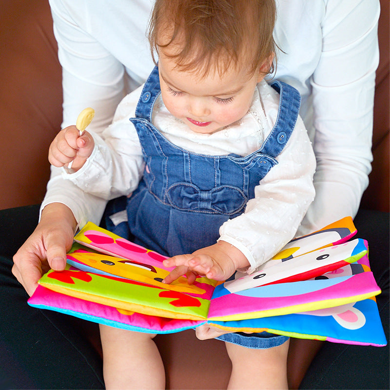 Baby reading a mix and match cloth book on a lap