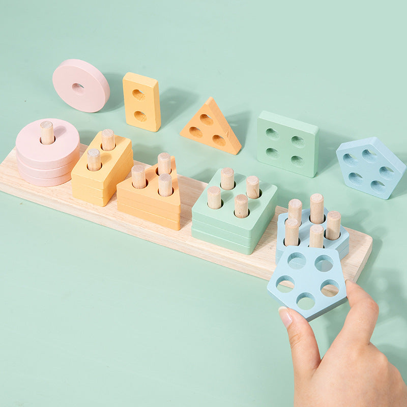 Pastel wooden shape stacker child placing a pentagon piece