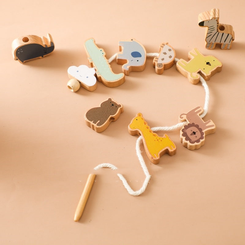 Wooden animals threaded on a cotton lacing cord