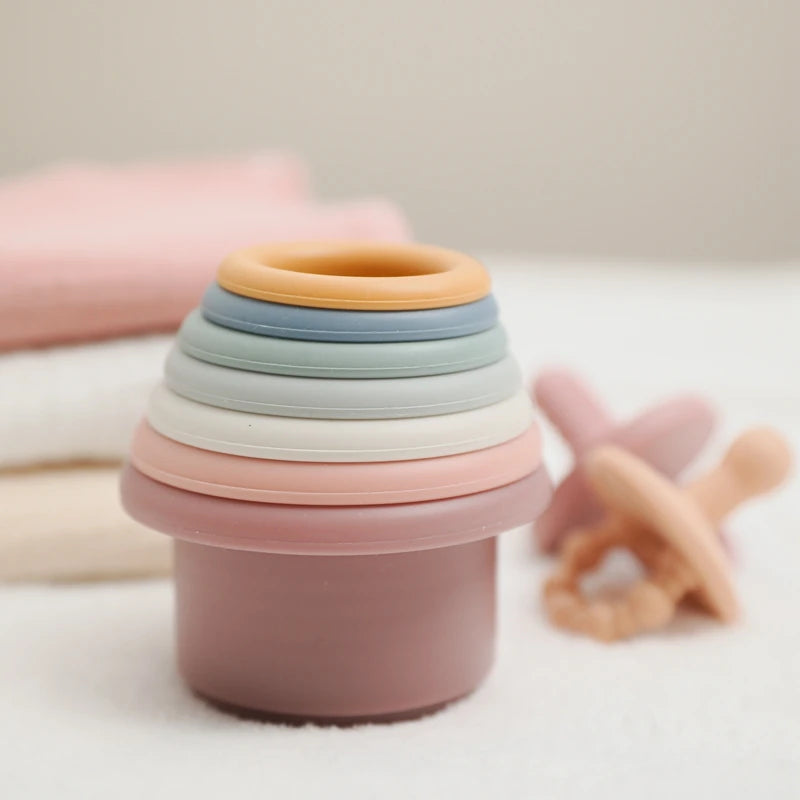 Discover the Montessori Silicone Stacking Cups at BubeBaby. Made from durable ABS, these versatile cups are perfect for beach, bath, and indoor play. Packaged in a net bag, they offer endless fun . Ideal for sensory play and skill development