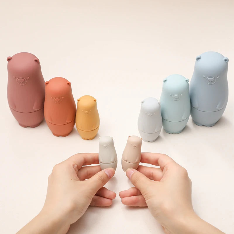 Montessori Silicone Bear Matryoshka Toy: A set of soft, stackable, bear-shaped nesting dolls in various sizes, made from pastel-colored, food-grade silicone. The bears fit inside one another, designed to encourage fine motor skills, sensory exploration, and cognitive development in young children