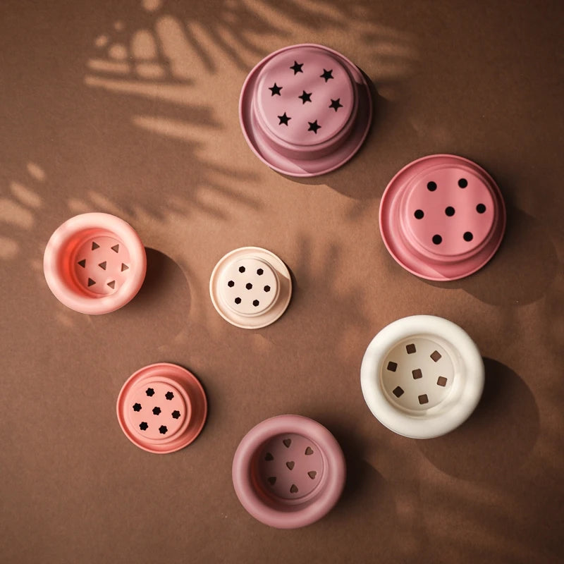Discover the Montessori Silicone Stacking Cups at BubeBaby. Made from durable ABS, these versatile cups are perfect for beach, bath, and indoor play. Packaged in a net bag, they offer endless fun . Ideal for sensory play and skill development