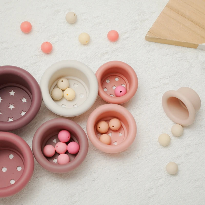 Discover the Montessori Silicone Stacking Cups at BubeBaby. Made from durable ABS, these versatile cups are perfect for beach, bath, and indoor play. Packaged in a net bag, they offer endless fun . Ideal for sensory play and skill development