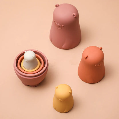 Montessori Silicone Bear Matryoshka Toy: A set of soft, stackable, bear-shaped nesting dolls in various sizes, made from pastel-colored, food-grade silicone. The bears fit inside one another, designed to encourage fine motor skills, sensory exploration, and cognitive development in young children