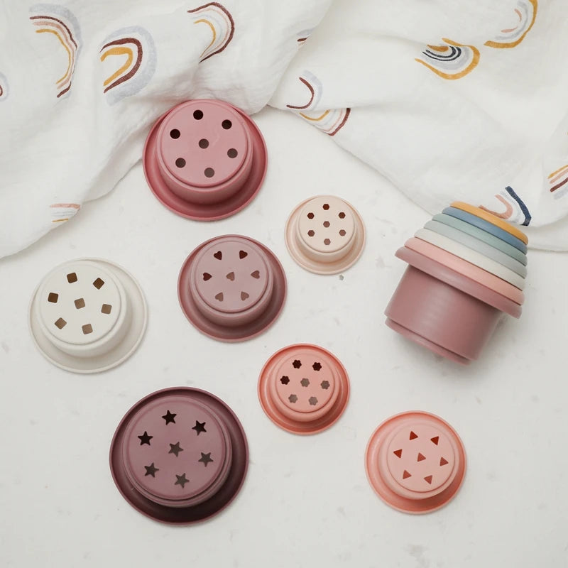Discover the Montessori Silicone Stacking Cups at BubeBaby. Made from durable ABS, these versatile cups are perfect for beach, bath, and indoor play. Packaged in a net bag, they offer endless fun . Ideal for sensory play and skill development