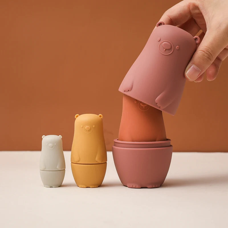 Montessori Silicone Bear Matryoshka Toy: A set of soft, stackable, bear-shaped nesting dolls in various sizes, made from pastel-colored, food-grade silicone. The bears fit inside one another, designed to encourage fine motor skills, sensory exploration, and cognitive development in young children