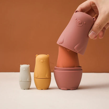 Montessori Silicone Bear Matryoshka Toy: A set of soft, stackable, bear-shaped nesting dolls in various sizes, made from pastel-colored, food-grade silicone. The bears fit inside one another, designed to encourage fine motor skills, sensory exploration, and cognitive development in young children