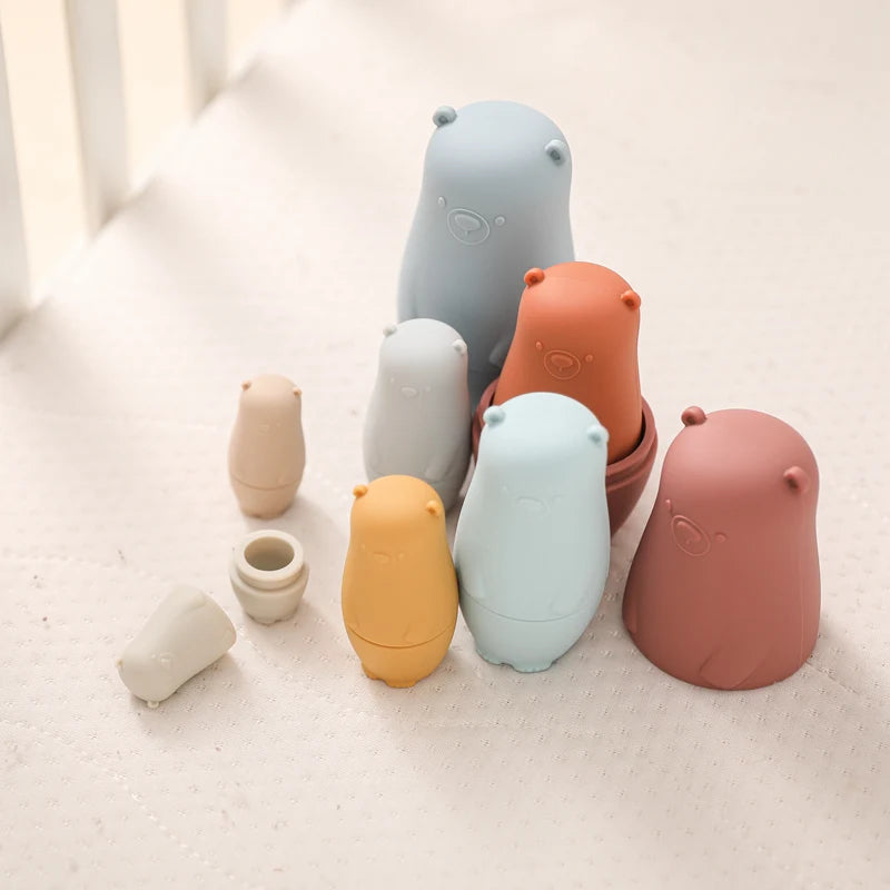 Montessori Silicone Bear Matryoshka Toy: A set of soft, stackable, bear-shaped nesting dolls in various sizes, made from pastel-colored, food-grade silicone. The bears fit inside one another, designed to encourage fine motor skills, sensory exploration, and cognitive development in young children