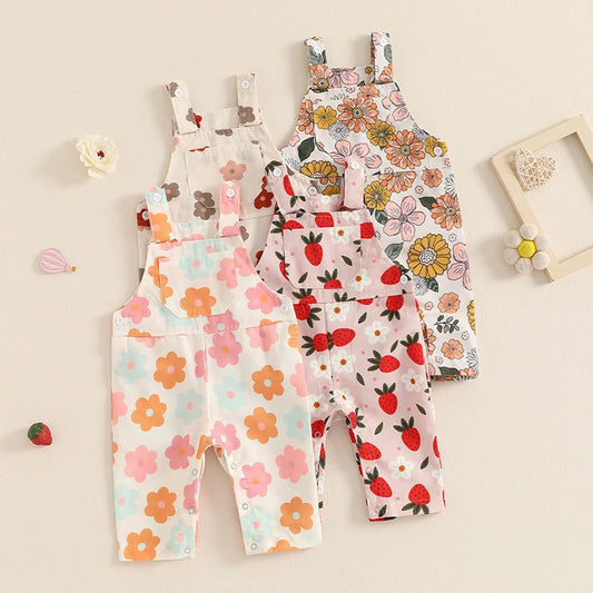 Bubebaby BabyLove Floral Jumpsuit Dungaree Romper. The romper features a floral pattern with a mix of vibrant colors. Featuring a pocket on the chest with shoulder straps, and snap closures at the bottom for easy diaper changes.