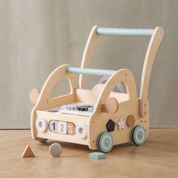 Wooden activity push walker with shape blocks on a wooden floor