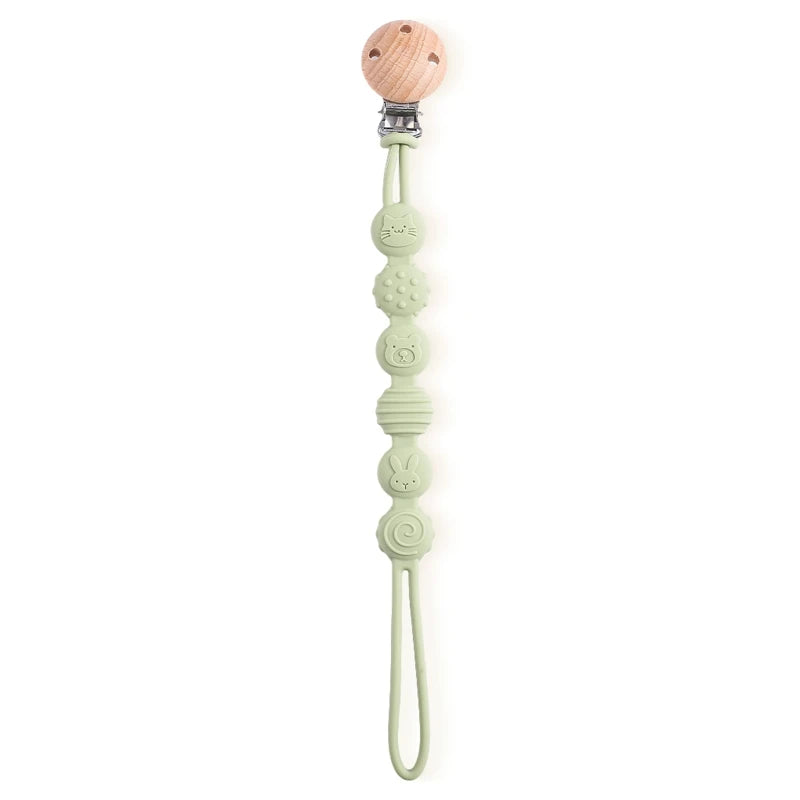 BabyLove Montessori Beech Wood and Silicone Beaded Pacifier Clip, a 20cm durable, BPA-free, phthalate-free, and latex-free accessory for babies aged 0-36 months. Features a solid color, wooden clip, and silicone strap. Versatile as a pacifier holder, soother chain, or teether toy. Safe and stylish design