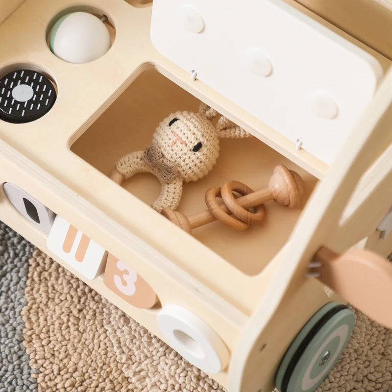 Open storage compartment of the push walker holding a crochet bunny rattle
