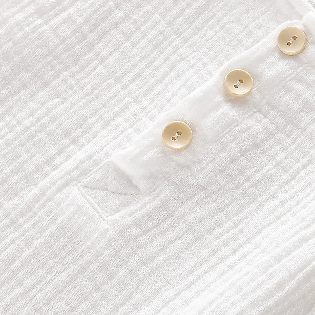 the BabyLove Sleeveless Romper at BubeBaby, designed for babies 0-24 months. Made from soft cotton, this solid-colored romper features an O-neck and covered button closure, perfect for summer