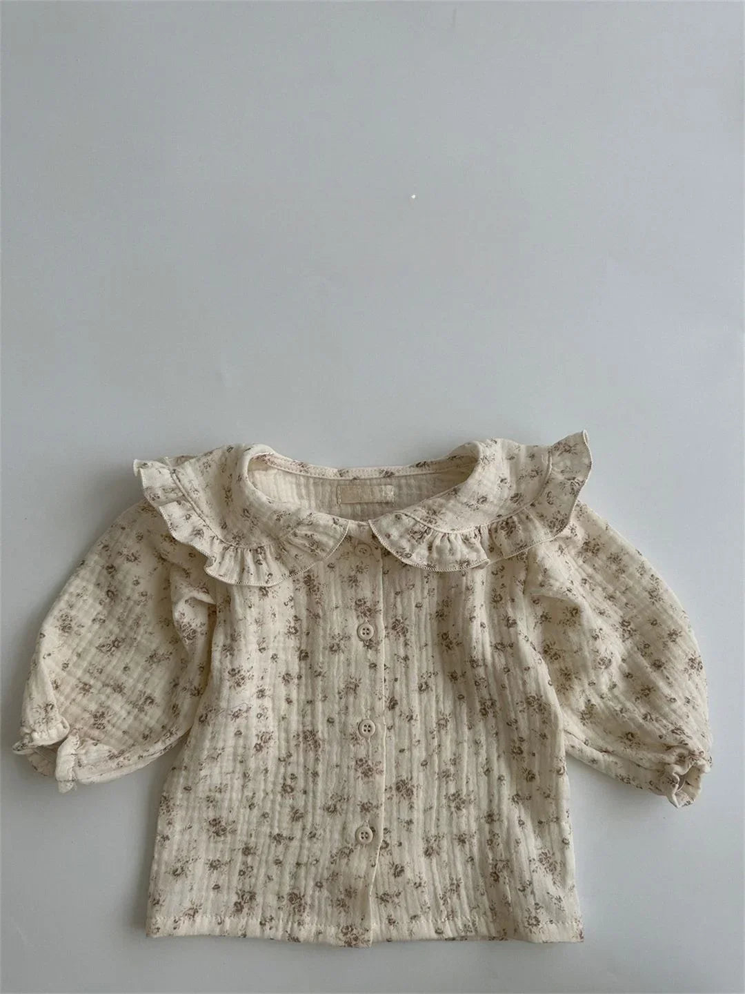 BabyLove by Bubebaby muslin/cotton full sleeve shirt in soft colors with a farm style feel. The shirt features a button-down front, peterpan collar , and gentle gathers at the sleeves for a comfortable fit. Ideal for keeping little ones cozy and stylish