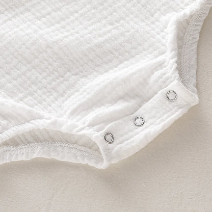the BabyLove Sleeveless Romper at BubeBaby, designed for babies 0-24 months. Made from soft cotton, this solid-colored romper features an O-neck and covered button closure, perfect for summer