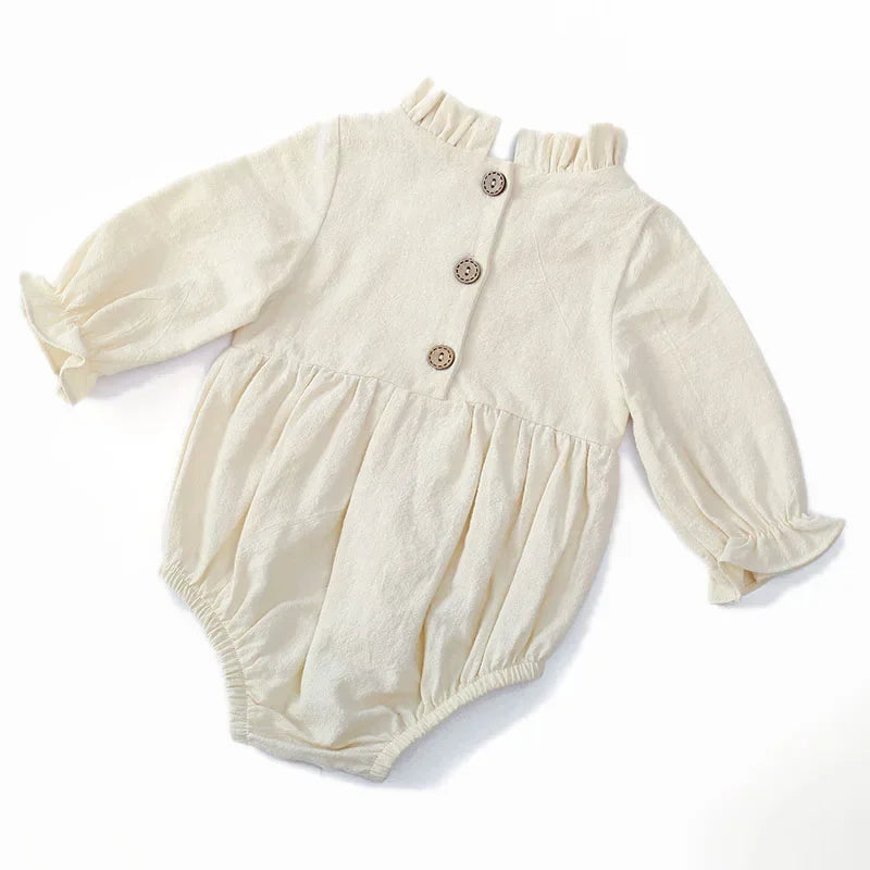 Bubebaby BabyLove Cotton Ruffled Long Sleeve buttoned Romper.  A cute and cozy baby romper made from soft cotton fabric, featuring long sleeves, a ruffled collar and wrists, with a snap closure for easy dressing. 