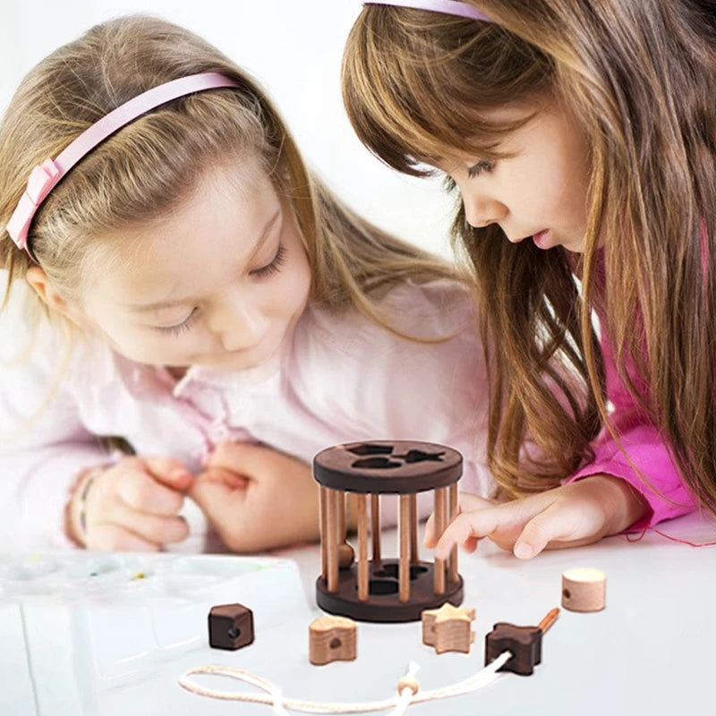 Two girls posting wooden shapes into the shape sorter