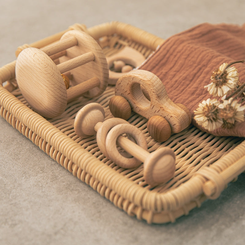 Wooden baby rattle set in a rattan tray