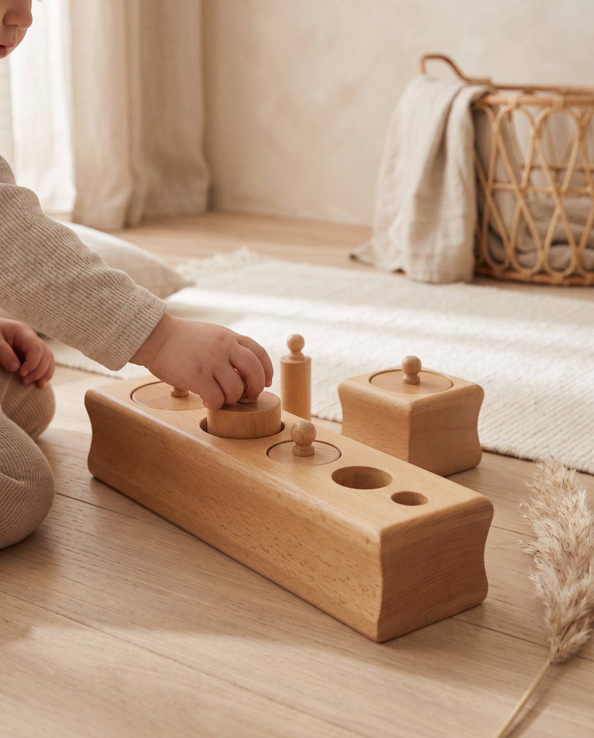 A toddler placing a cylinder into a wooden Montessori block