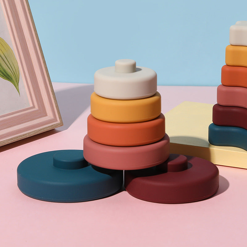 Earth tones silicone stacking ring tower on a pink table