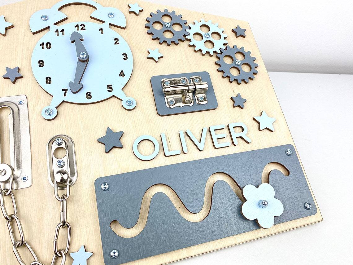 House shaped wooden busy board close-up of latch, chain lock and slider