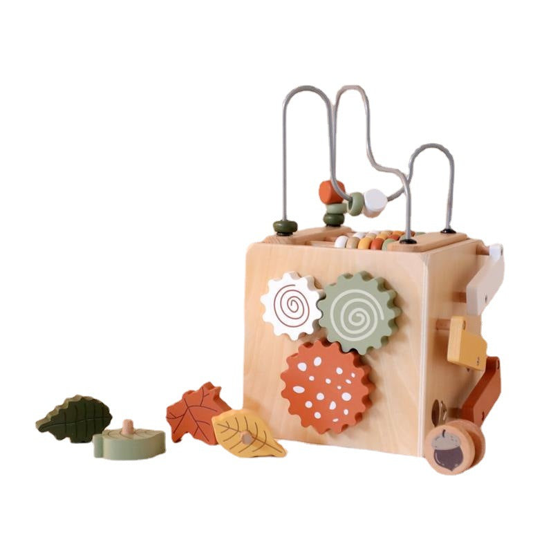Wooden activity cube with leaf shapes on white background